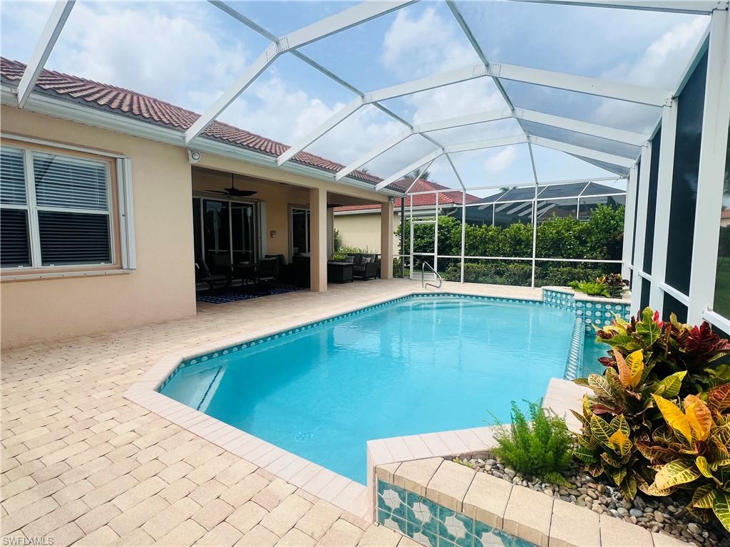 View of swimming pool featuring a lanai, a patio, and ceiling fan