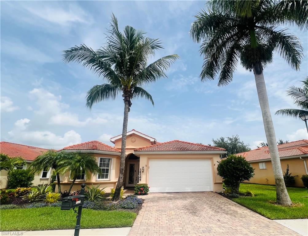 Mediterranean / spanish-style home featuring a garage and a front lawn