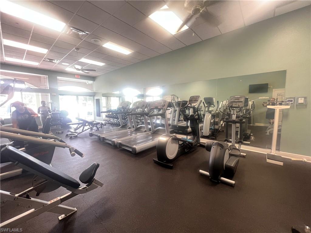 Workout area featuring ceiling fan and a paneled ceiling