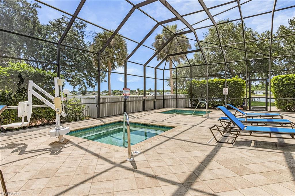 Screened outdoor enclosure featuring two in-ground pools, a tiled patio, and lounge chairs.