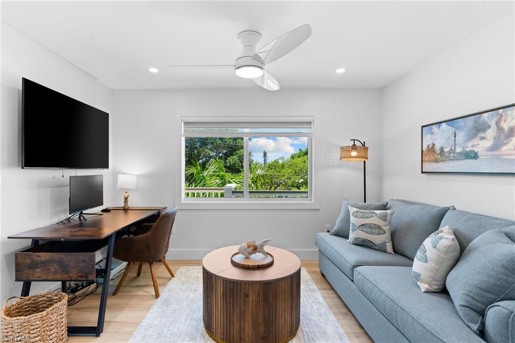 Bright room with a large window, recessed lighting, and a ceiling fan