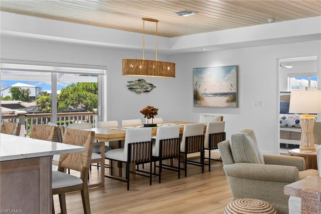 Open-concept dining area featuring wood-finish flooring and a wood-paneled ceiling