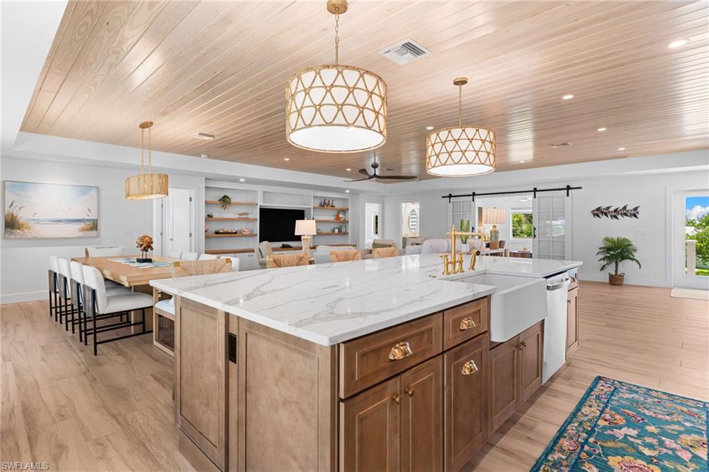 Kitchen island with a white marble-look countertop and white farmhouse sink