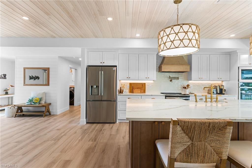 Open-concept kitchen with wood-finish flooring and a wood plank ceiling