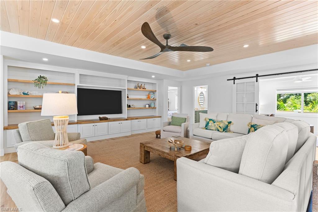 Living area featuring a natural wood-finish plank ceiling and recessed lighting