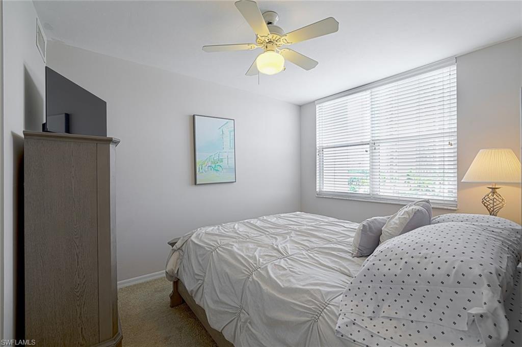 Carpeted bedroom featuring ceiling fan