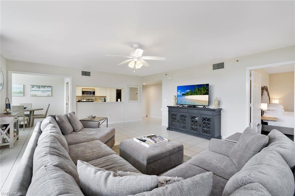 Living room with ceiling fan and light tile floors