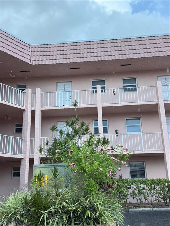 Multi-level building exterior featuring a tiled roof and stucco finish