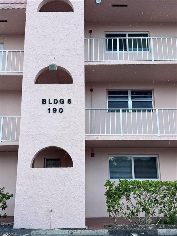 Pink stucco exterior featuring multiple balconies with white railings