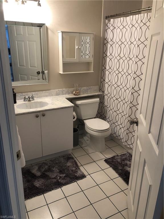 Bathroom featuring a single vanity with a white cabinet, integrated sink, and stone-finish countertop