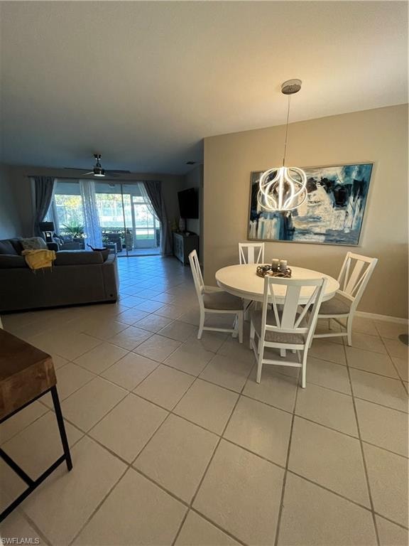 Dining area featuring a contemporary pendant light fixture, tile flooring, and a neutral wall color