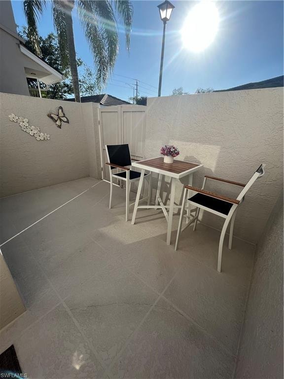 Private patio space featuring textured wall finishes and concrete slab flooring
