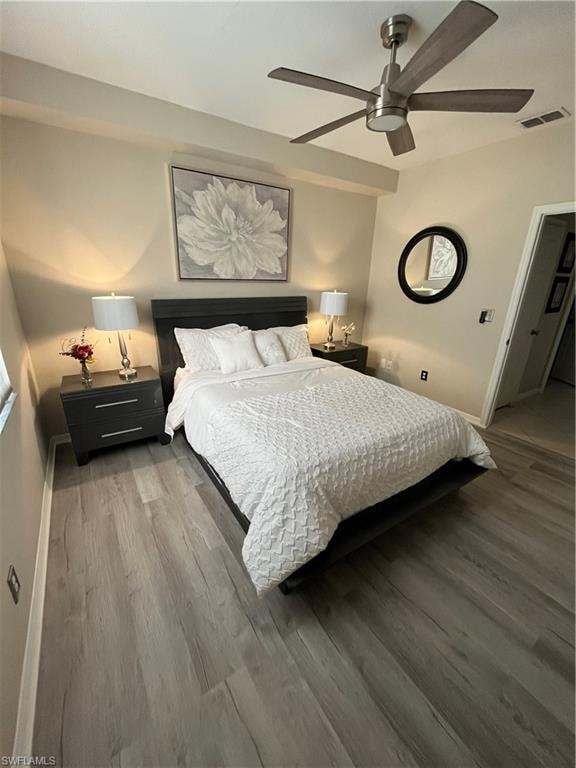 Bedroom featuring wood-finish flooring, a contemporary ceiling fan, neutral wall tones, and built-in lighting fixtures