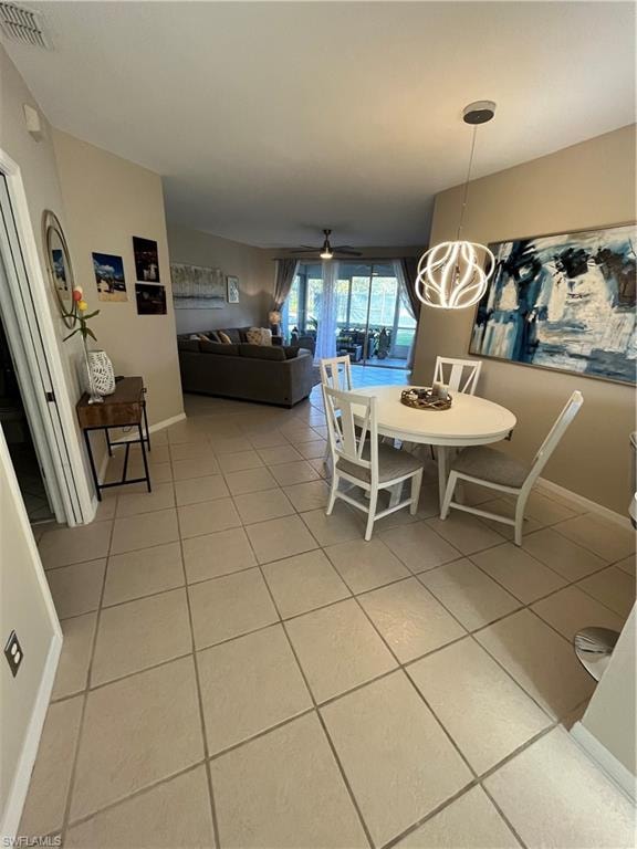 Dining area featuring tile flooring, a contemporary suspended light fixture, and a neutral color palette