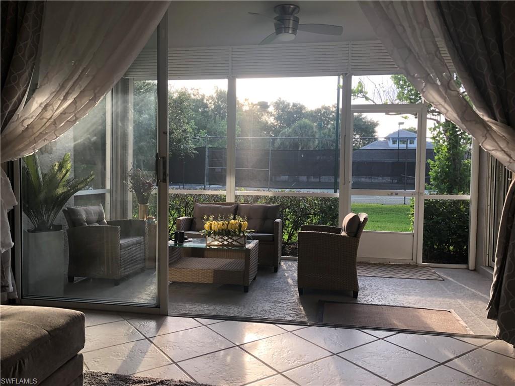 Expansive screened lanai featuring tile flooring, a ceiling fan, and sliding glass doors
