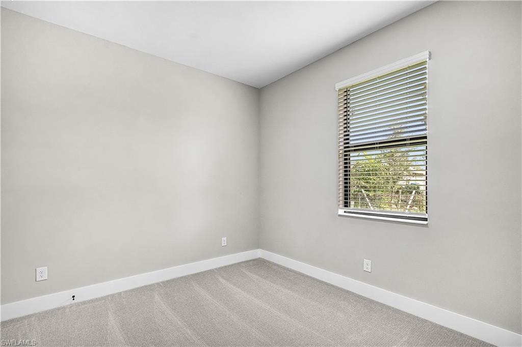 Carpeted spare room with baseboards