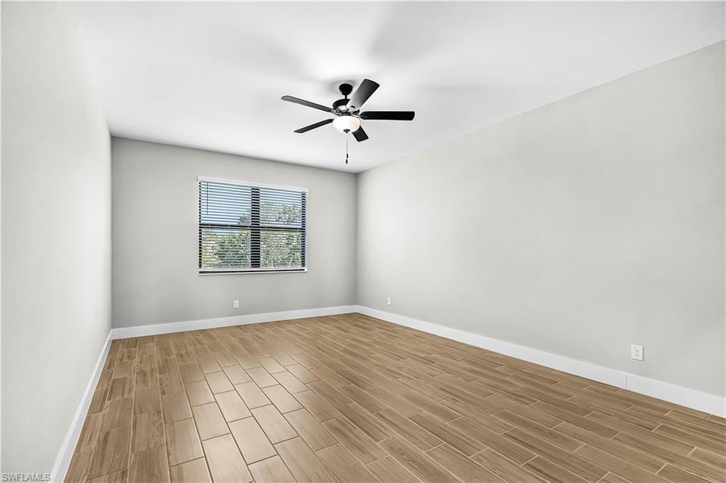 Spare room featuring wood tiled floors and ceiling fan
