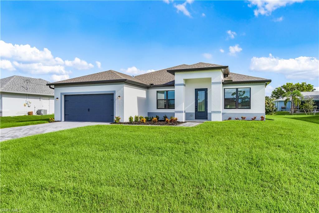 Prairie-style home with a front lawn, driveway, stucco siding, a garage, and a shingled roof