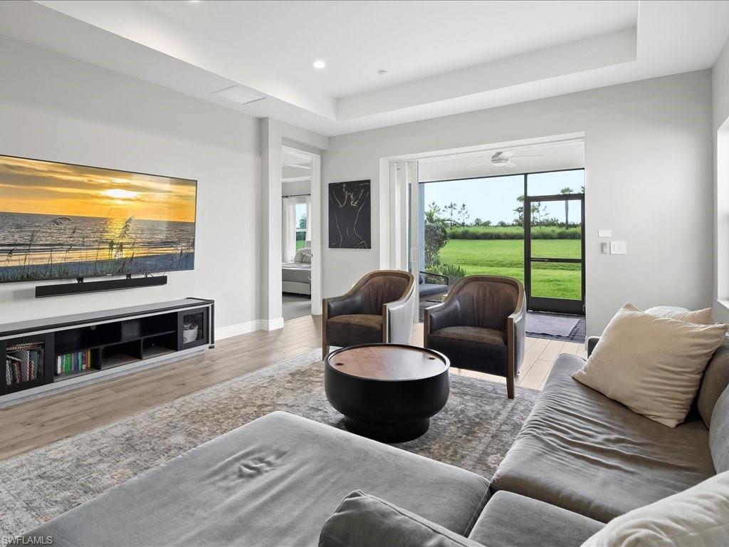Living area featuring light wood-finish flooring and a tray ceiling