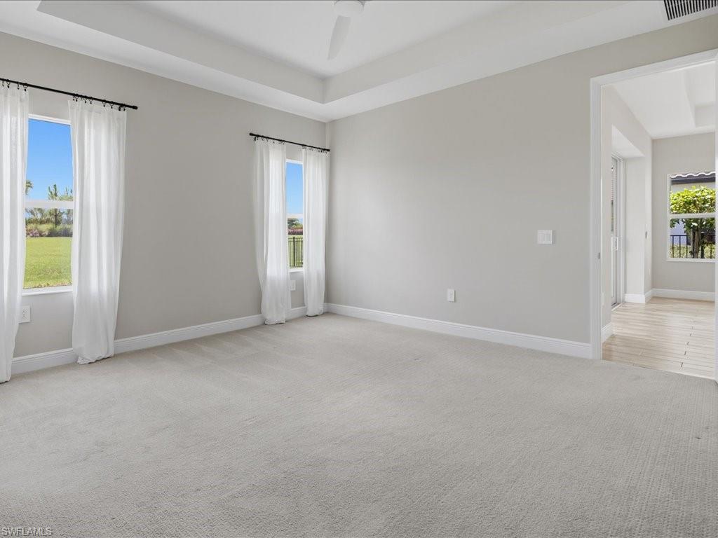 Spacious room featuring light gray walls and plush carpeting