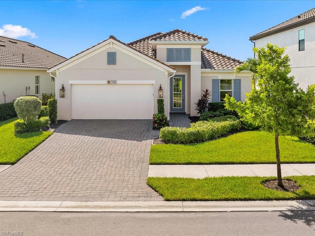Contemporary stucco exterior featuring a tile roof and decorative shutters