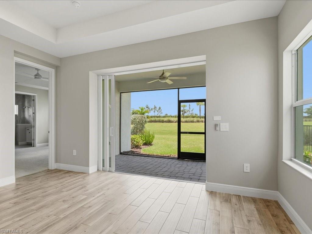 Interior space featuring wood-finish flooring, a tray ceiling, and a large window
