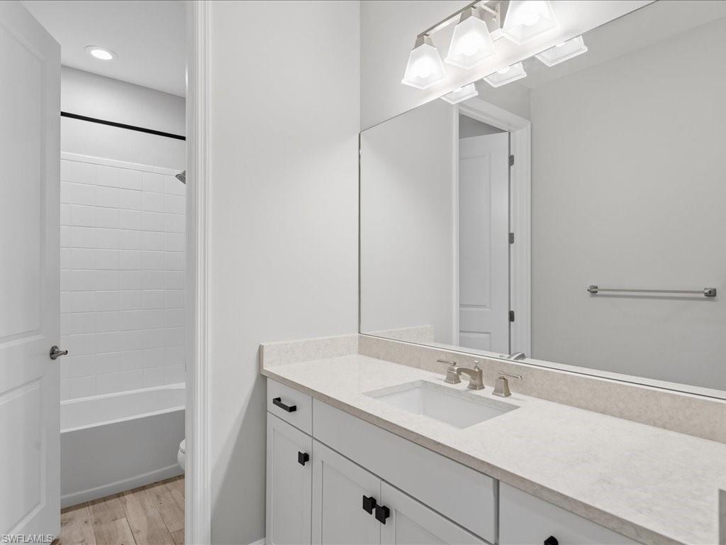 Bathroom vanity featuring a light-colored countertop, undermount sink, and brushed nickel faucet
