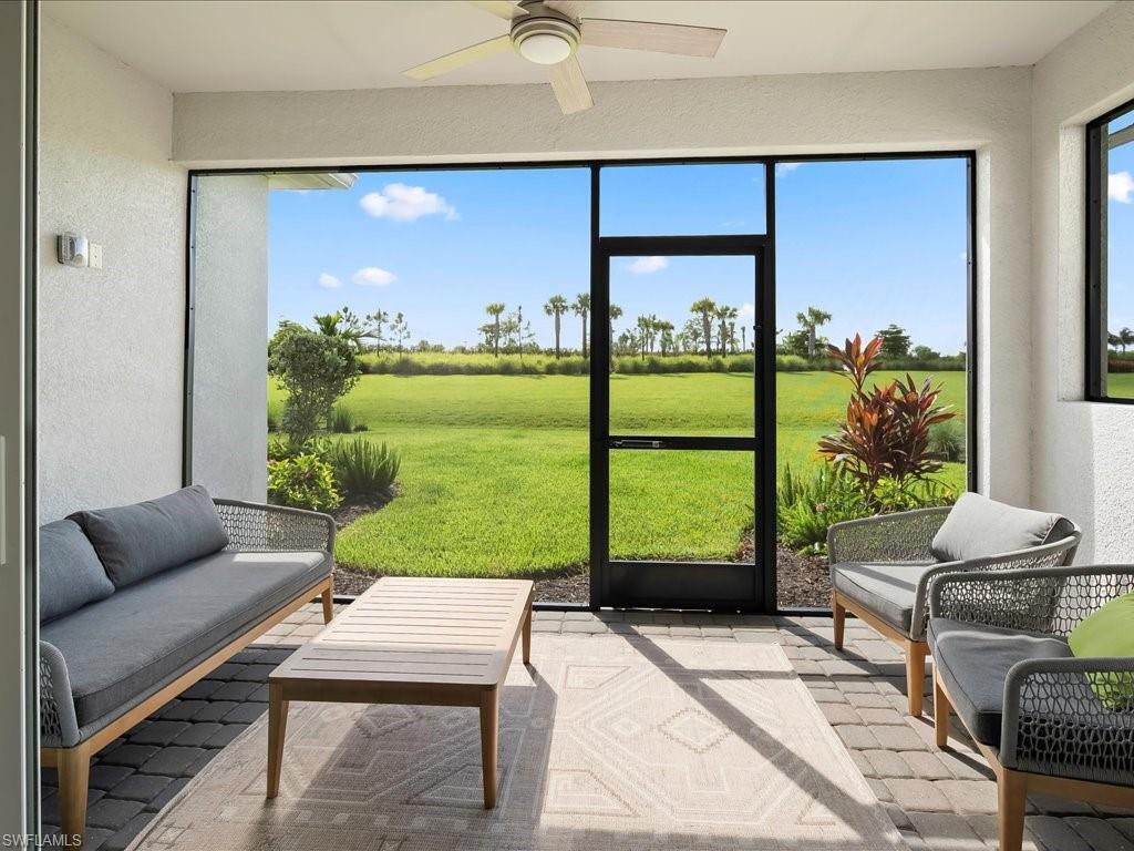 Screened patio featuring paver flooring, a ceiling fan, and direct access to a manicured lawn