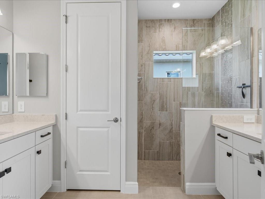 Walk-in shower with large format tile walls and a mosaic accent strip