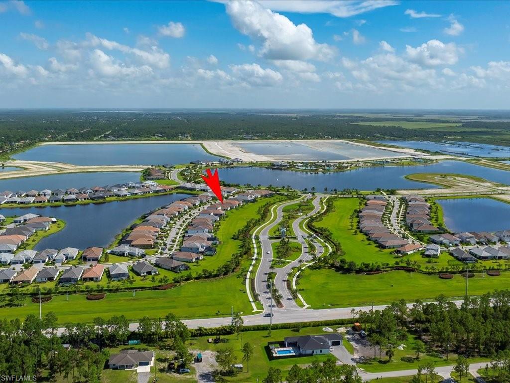 Aerial perspective highlighting a waterfront community with extensive water features, manicured green spaces, and a network of winding roads