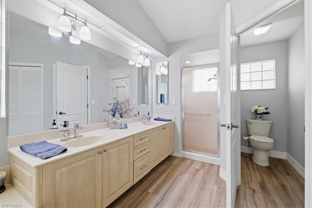 Double vanity with light wood-finish cabinetry and light-colored countertops
