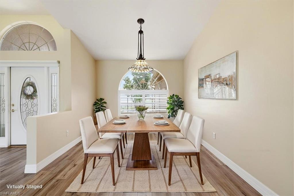 *VIRTUALLY STAGED* Formal dining area featuring wood-finish flooring, neutral-toned walls, and a decorative pendant light fixture