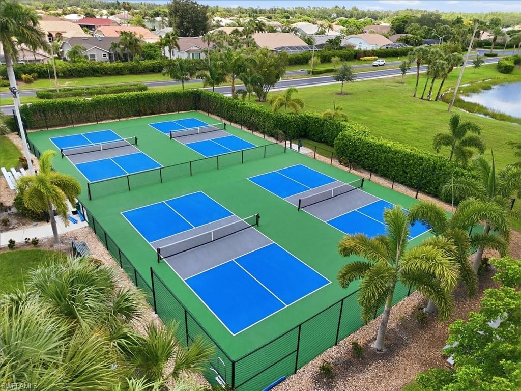 Four professional-grade pickleball courts featuring blue and gray playing surfaces
