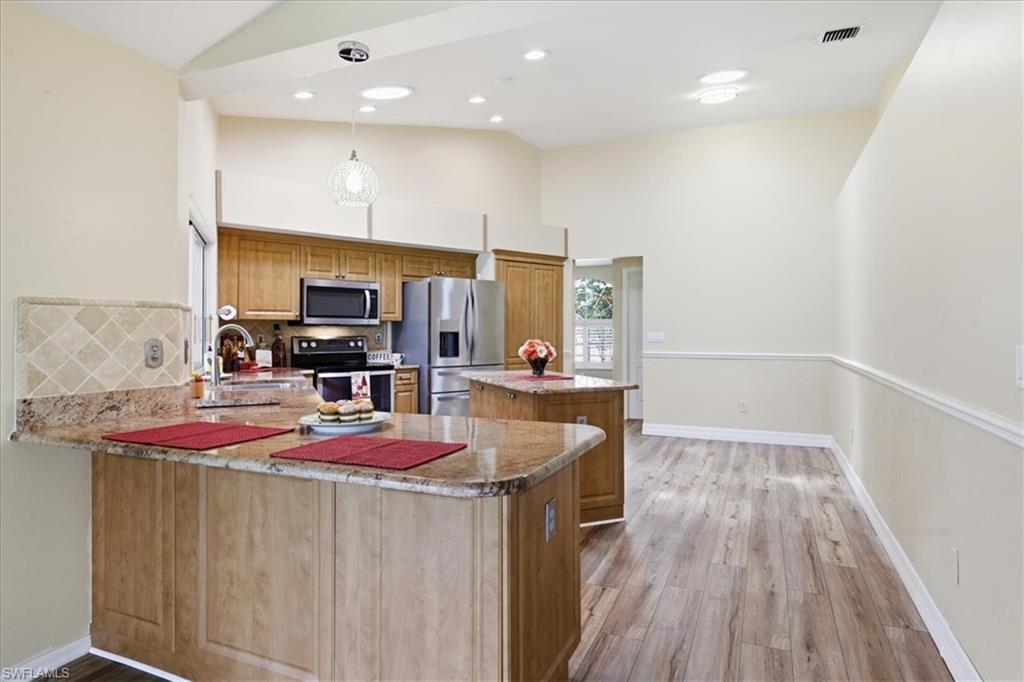 Kitchen featuring wood cabinetry, stainless steel appliances, and granite countertops