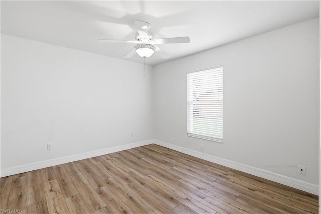 Bright room with wood-finish flooring and a white ceiling fan
