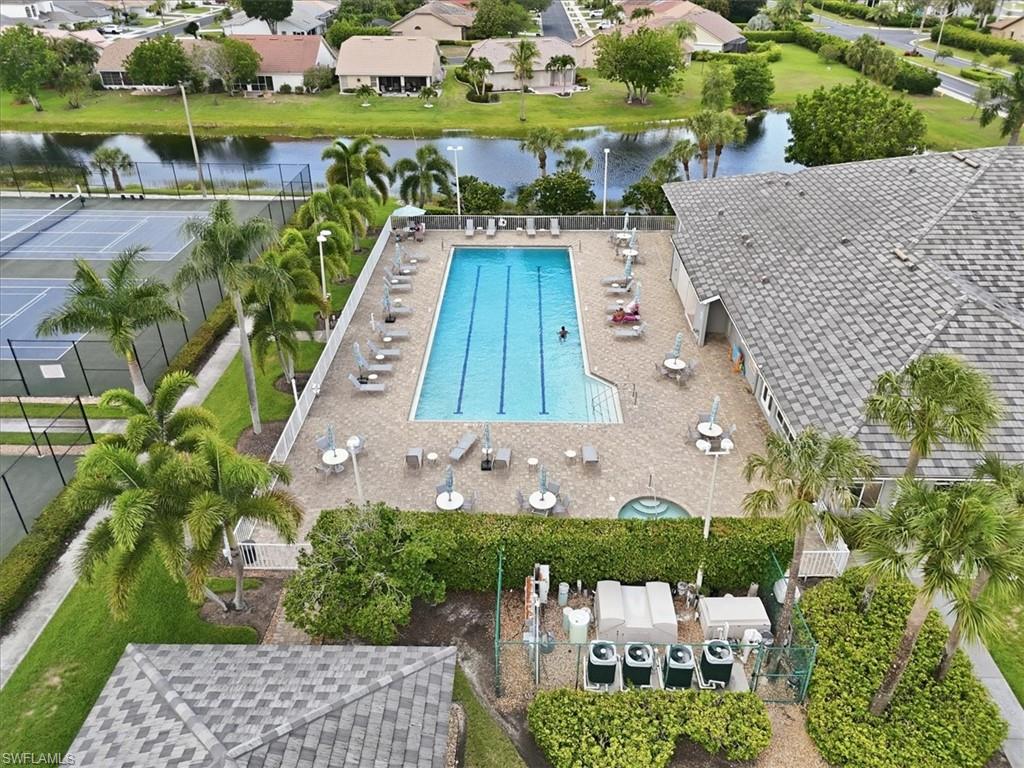 Community swimming pool with a paved deck, an adjacent spa, and multiple tennis courts