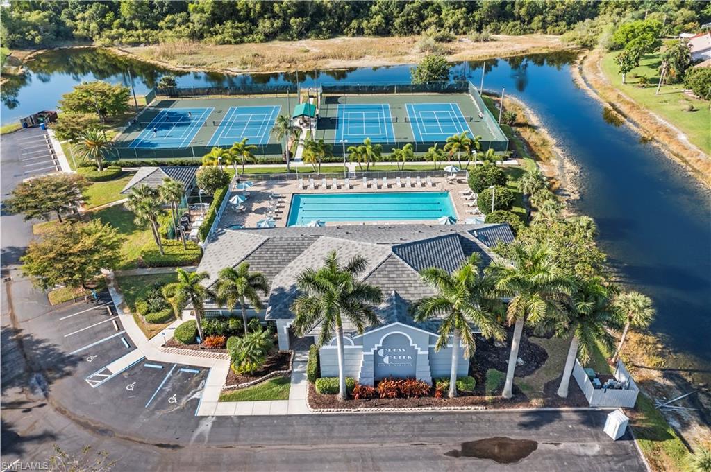 Community amenities featuring a clubhouse, swimming pool with deck, multiple tennis courts, and ample parking