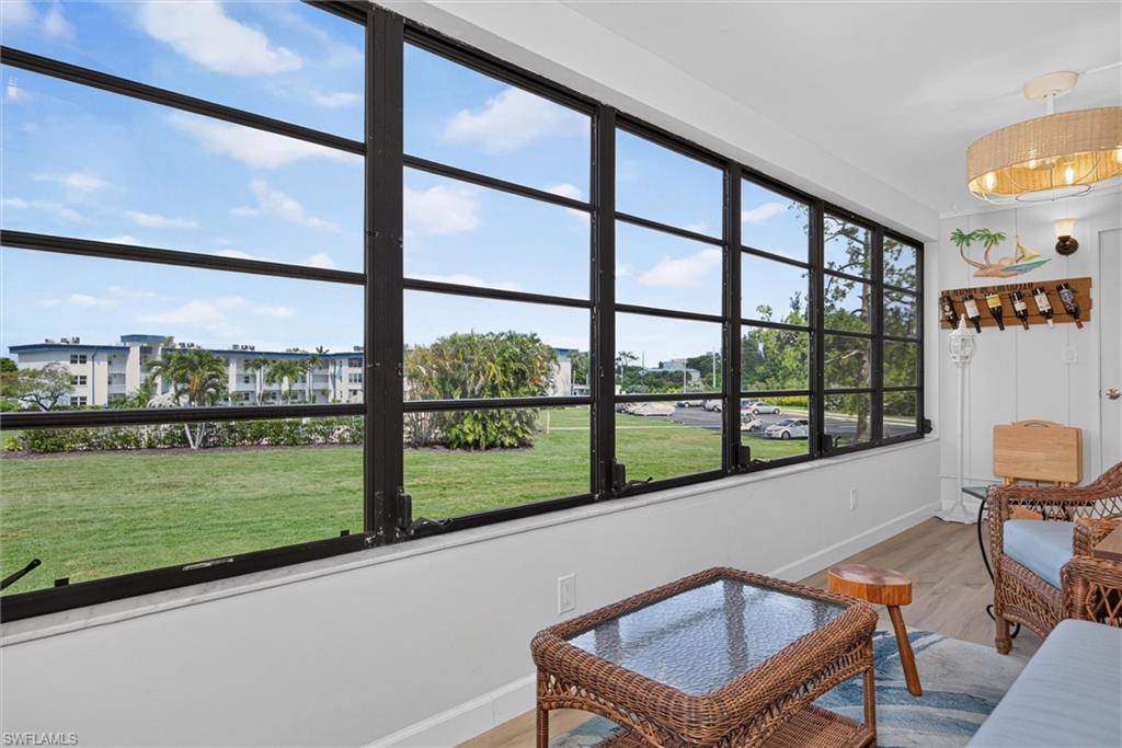 Lanai featuring a full wall of multi-pane windows and light-toned wood-finish flooring