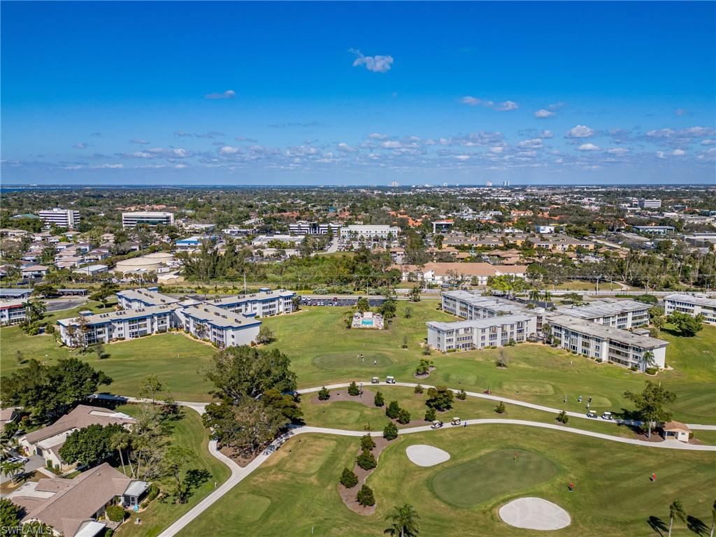 Expansive golf course property featuring multiple low-rise residential buildings, mature trees, manicured greens, and sand traps