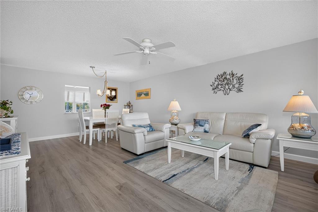 Open-concept living and dining area featuring wood-finish flooring, a ceiling fan, and recessed lighting