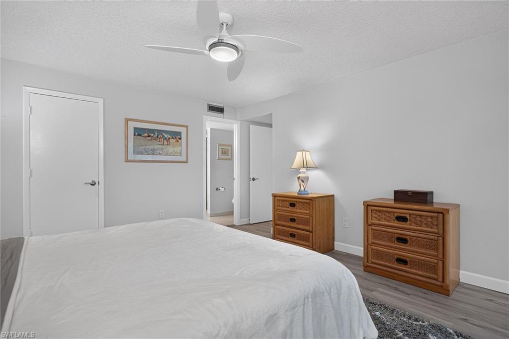 Spacious Master Bedroom featuring wood-finish flooring, light gray walls, and a contemporary ceiling fan with integrated lighting