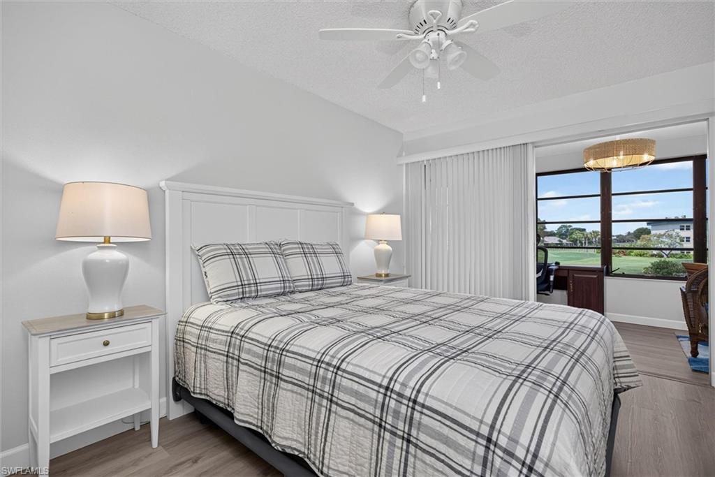 Guest Bedroom Bright interior space featuring a white paneled headboard, light wood-finish flooring, and a ceiling fan with integrated lighting