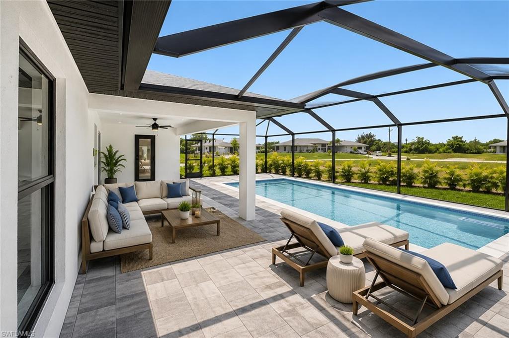 Expansive screened-in lanai featuring a rectangular swimming pool, integrated covered patio, and textured paver flooring