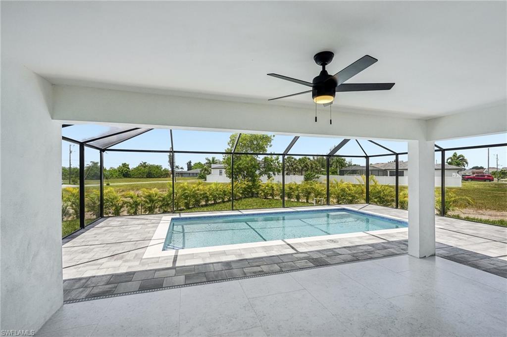 Screened lanai featuring a swimming pool, a ceiling fan with integrated lighting, and a paver deck