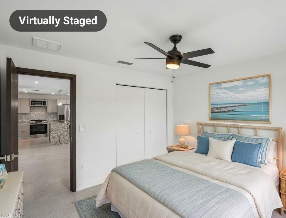 Bedroom featuring a ceiling fan with integrated lighting, a double-door closet, and wood-finish flooring