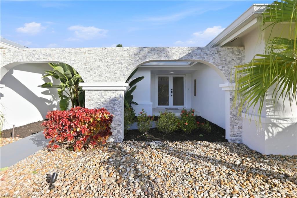 Property entrance featuring stucco siding and stone siding