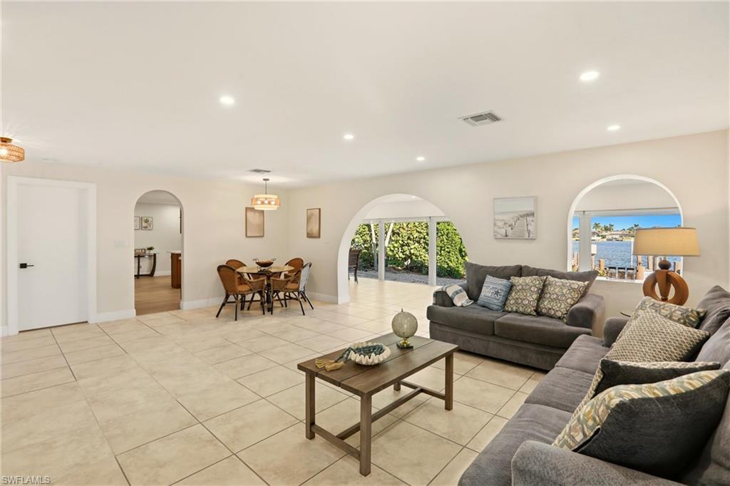 Living area featuring arched walkways, recessed lighting, and light tile patterned floors