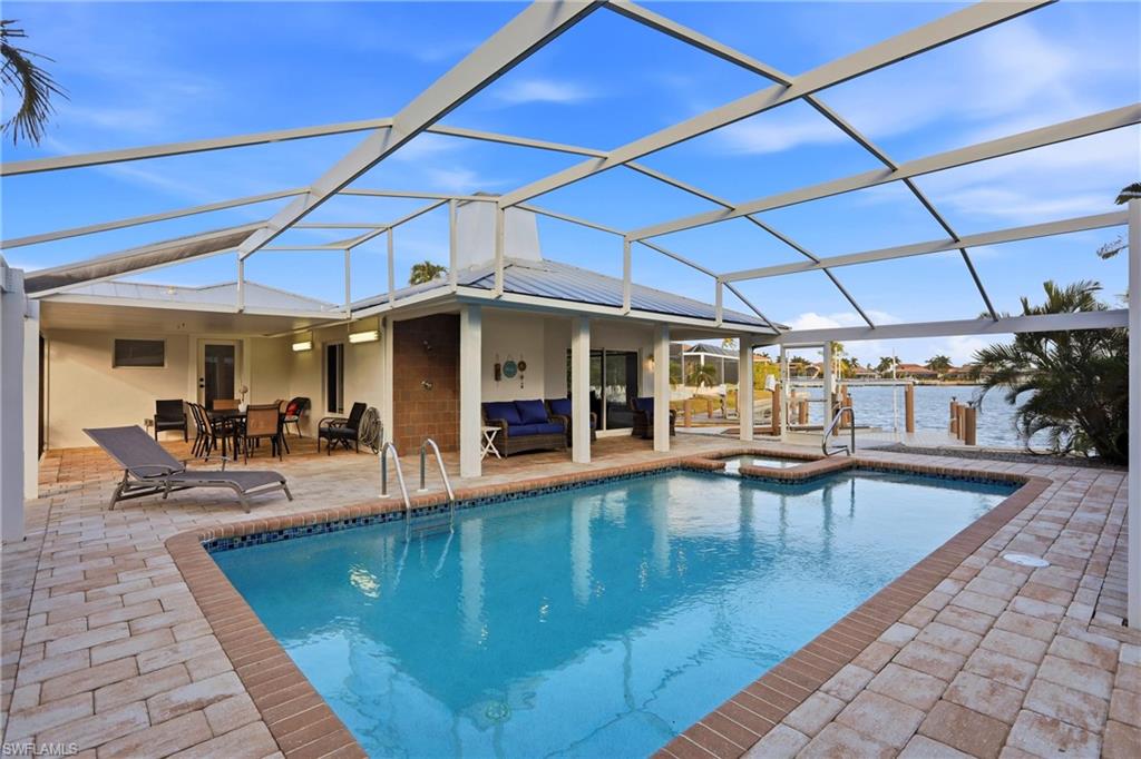 View of swimming pool featuring a lanai, a sunroom, an outdoor living space, and a patio