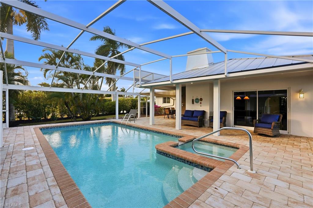 View of pool with a patio area, a lanai, a pool with connected hot tub, a sunroom, and outdoor lounge area