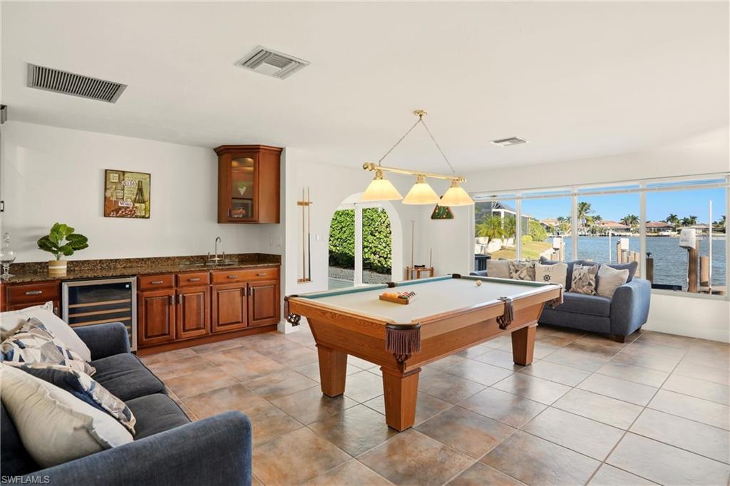 Game room featuring billiards table, wine cooler, a water view, and wet bar